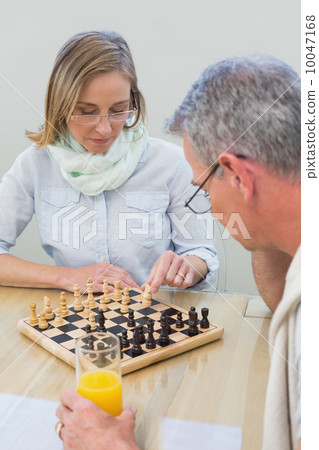 Couple playing chess at home Couple playing chess at home 10047168
