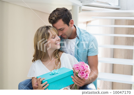 Couple with flowers and gift box sitting on stairs Couple with flowers and gift box sitting on stairs 10047170