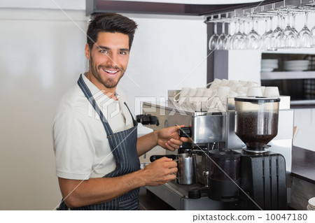 Waiter smiling and making cup of coffee at coffee shop 10047180