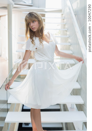 Young woman standing on stairs 10047290