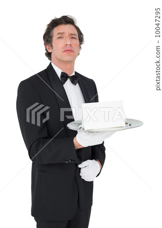 Confident waiter holding tray against white background Confident waiter holding tray against white background 10047295