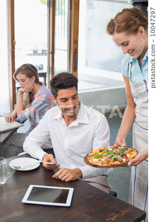 Waitress giving pizza to a man at coffee shop Waitress giving pizza to a man at coffee shop 10047297