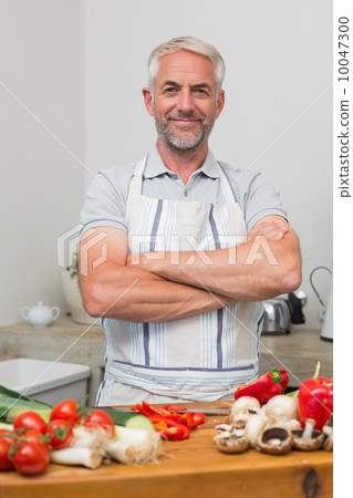 Portrait of a mature man with vegetables in kitchen Portrait of a mature man with vegetables in kitchen 10047300