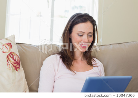 Woman using digital tablet at home Woman using digital tablet at home 10047306