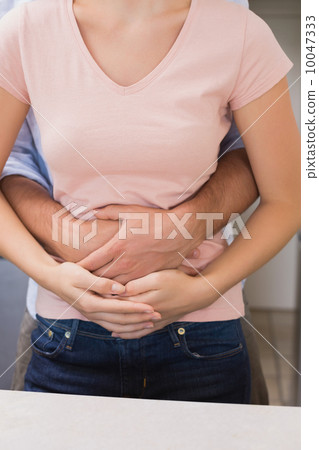 Man embracing woman from behind 10047333