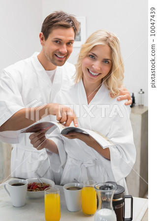 Happy young couple with recipe book in kitchen 10047439