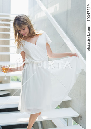 Thoughtful beautiful woman with wine glass on stairs 10047519