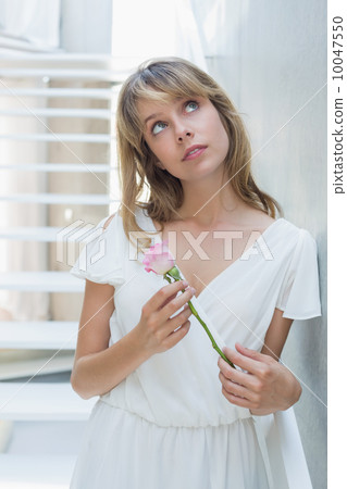 Thoughtful beautiful woman with a flower 10047550