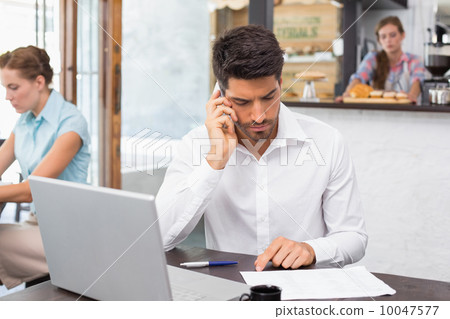 Man using mobile phone in coffee shop 10047577
