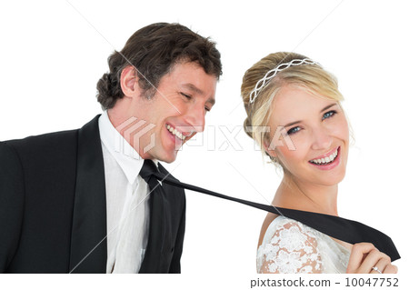 Attractive bride pulling tie of groom 10047752