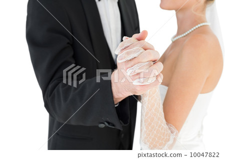 Mid section of bride and groom holding hands 10047822
