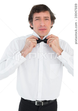 Man adjusting bow tie before wedding Man adjusting bow tie before wedding 10047889
