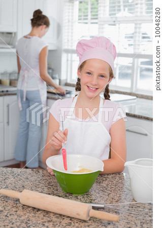 Girl helping her mother prepare food in kitchen Girl helping her mother prepare food in kitchen 10048280