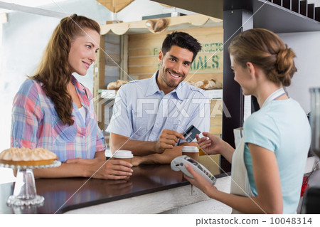 Couple paying bill at coffee shop using card bill Couple paying bill at coffee shop using card bill 10048314