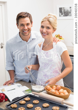Happy couple preparing cookies in the kitchen 10048338