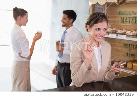 Businesswoman using mobile phone in office cafeteria Businesswoman using mobile phone in office cafeteria 10048339