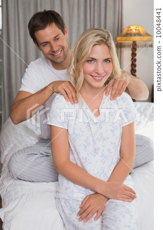 Man massaging woman's shoulders in bed Man massaging woman's shoulders in bed 10048441
