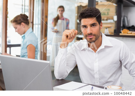 Man using laptop in coffee shop Man using laptop in coffee shop 10048442