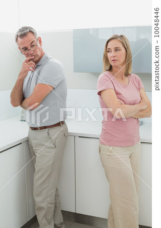 Unhappy couple not talking after an argument in kitchen Unhappy couple not talking after an argument in kitchen 10048446