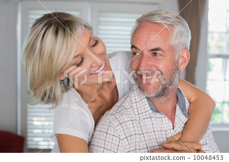 Close-up of a happy woman embracing mature man Close-up of a happy woman embracing mature man 10048453