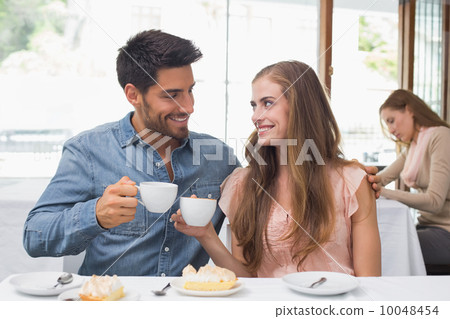 Smiling couple having coffee at coffee shop Smiling couple having coffee at coffee shop 10048454
