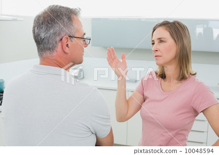 Unhappy couple having an argument in kitchen Unhappy couple having an argument in kitchen 10048594