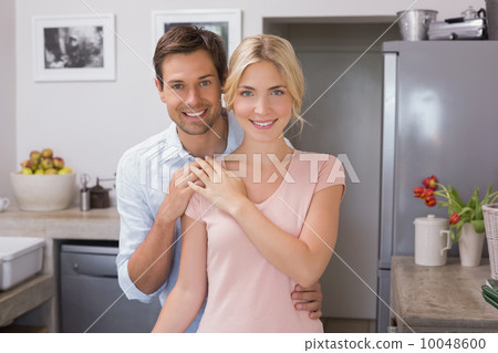 Portrait of a happy loving young couple in kitchen Portrait of a happy loving young couple in kitchen 10048600