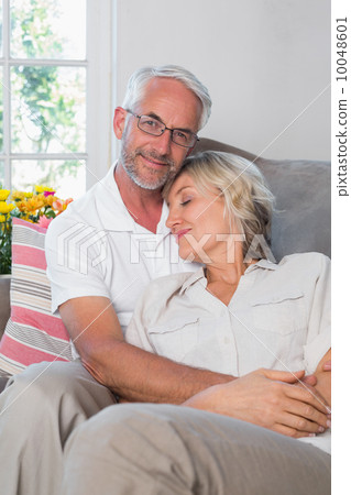 Portrait of a relaxed mature couple sitting on sofa Portrait of a relaxed mature couple sitting on sofa 10048601