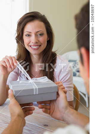 Cropped man giving woman a gift box at home Cropped man giving woman a gift box at home 10048697