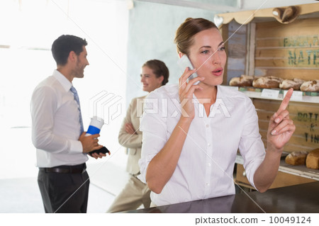 Businesswoman using mobile phone in office cafeteria Businesswoman using mobile phone in office cafeteria 10049124