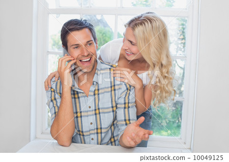 Happy man on call besides a woman at home Happy man on call besides a woman at home 10049125