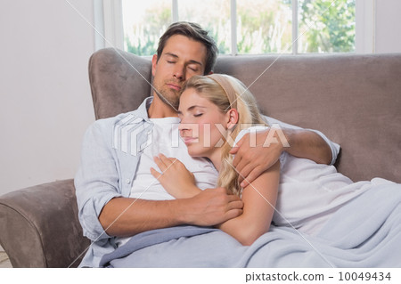 Loving young couple sleeping together on sofa Loving young couple sleeping together on sofa 10049434