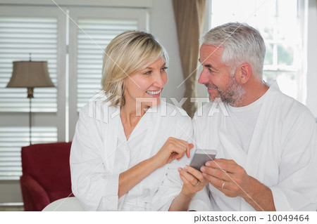 Couple reading text message at home Couple reading text message at home 10049464