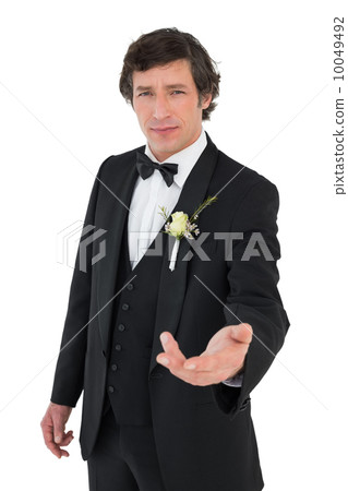 Confident groom in tuxedo offering hand 10049492