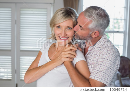 Mature man kissing a happy woman Mature man kissing a happy woman 10049714