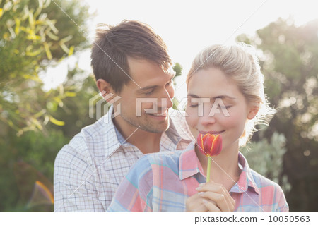 Young couple holding a flower in park Young couple holding a flower in park 10050563
