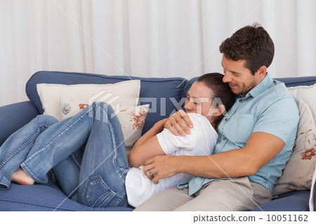 Loving young couple sitting on couch Loving young couple sitting on couch 10051162