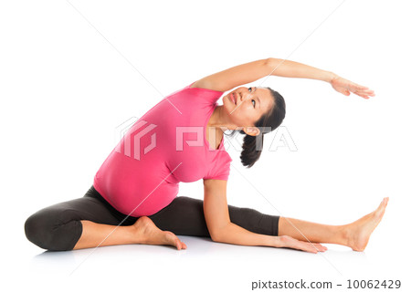 Pregnant woman yoga position seated side stretch. 10062429