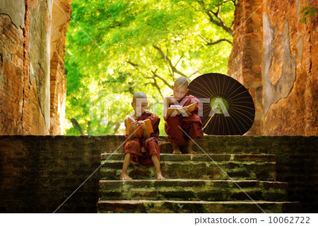 Buddhist monk reading outdoors 10062722