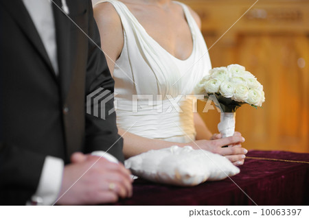 Bride holding white wedding flowers bouquet 10063397