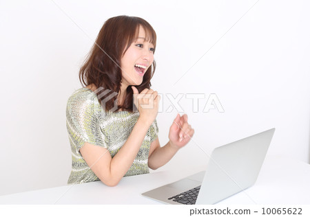 一個女人高興地看到一台電腦 10065622