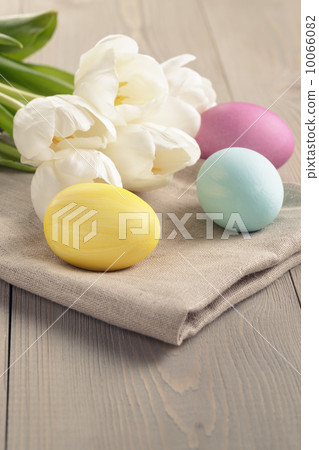 pastel color easter eggs with tulips on table 10066082