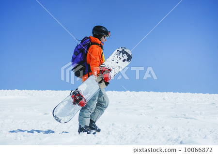 Snowboarder walking at the mountains Snowboarder walking at the mountains 10066872
