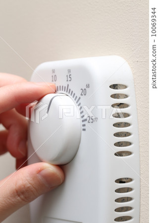 Woman hand setting a thermostat 10069344