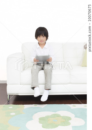 A boy watching an iPad in the living room 10070675