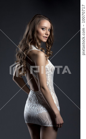 Seductive curly girl posing in short dress 10070717