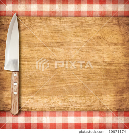Cutting breadboard and knife over red grunge gingham tablecloth 10071174