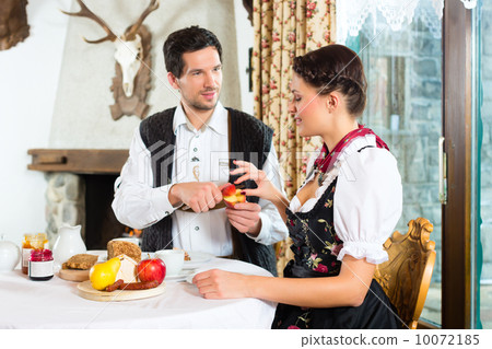 Young couple in a hunter's cabin eating 10072185