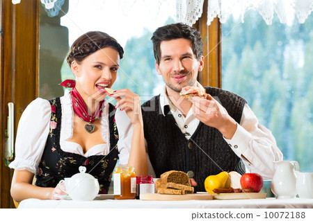 Young couple in a hunter's cabin eating 10072188
