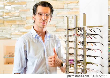Young man at optician with glasses 10072336